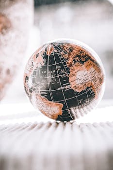 Artistic image of a globe with warm tones, showcasing continents and oceans in close-up view.