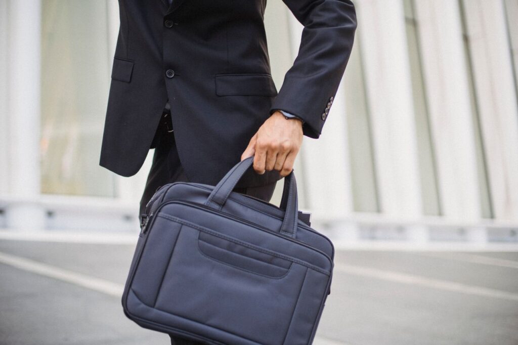 Close-up of a businessman carrying a briefcase in urban environment.